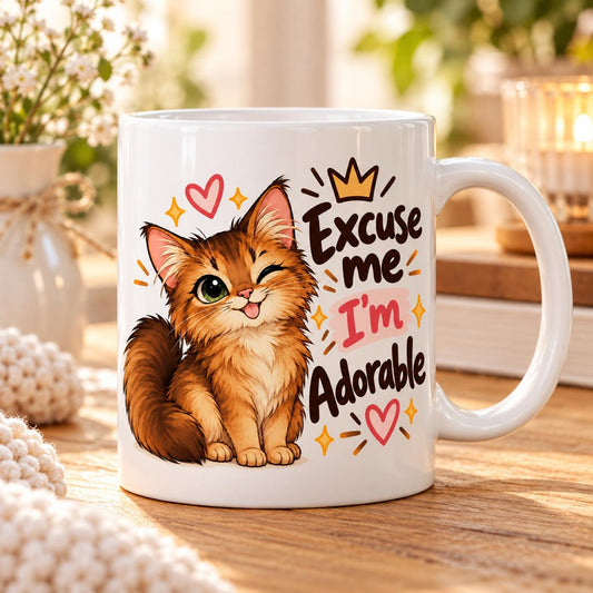 Rendering of white ceramic mug with cartoon happy somali cat saying "Excuse me I'm adorable" on wooden table.