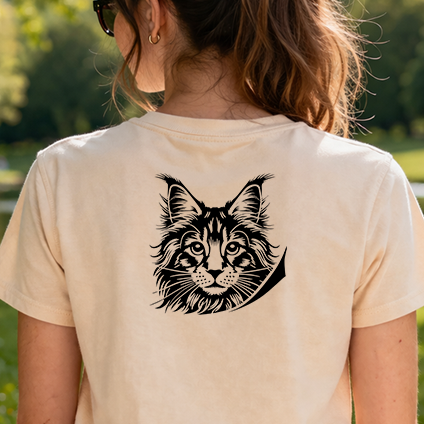 Černobílá stylizovaná nažehlovačka mainské mývalí kočky vykukující přes hranu s tlapkami aplikovaná na zadní straně pískového trička.