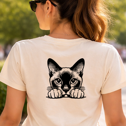 Černobílá stylizovaná nažehlovačka siamské kočky vykukující přes hranu s tlapkami aplikovaná na zadní straně pískového trička.