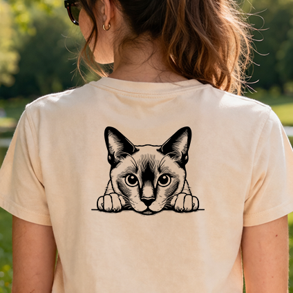 Černobílá stylizovaná nažehlovačka tonkinské kočky vykukující přes hranu s tlapkami aplikovaná na zadní straně pískového trička.