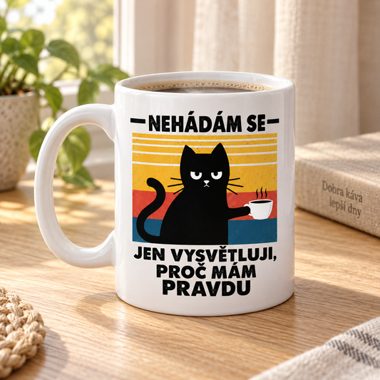 Lifestylová fotografie bílý keramický hrnek s černou kočkou, šálkem kávy a vtipným nápisem Nehádám se, jen vysvětluji, proč mám pravdu.
