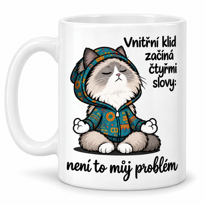 Bílý keramický hrnek s meditující kočkou v mikině a vtipným nápisem Vnitřní klid začíná čtyřmi slovy: není to můj problém.
