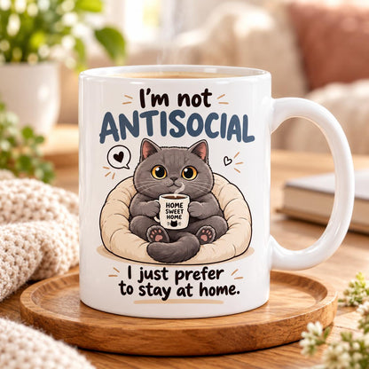 Rendering of white ceramic mug with cartoon happy british cat saying "I'm not antisocial ..." on wooden table. 