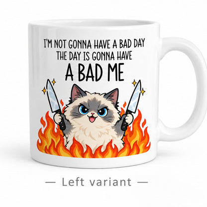 Rendering of white ceramic mug with cartoon pumped ragdoll cat saying "I'm not gonna have a bad day" on white background. Print on left side view.