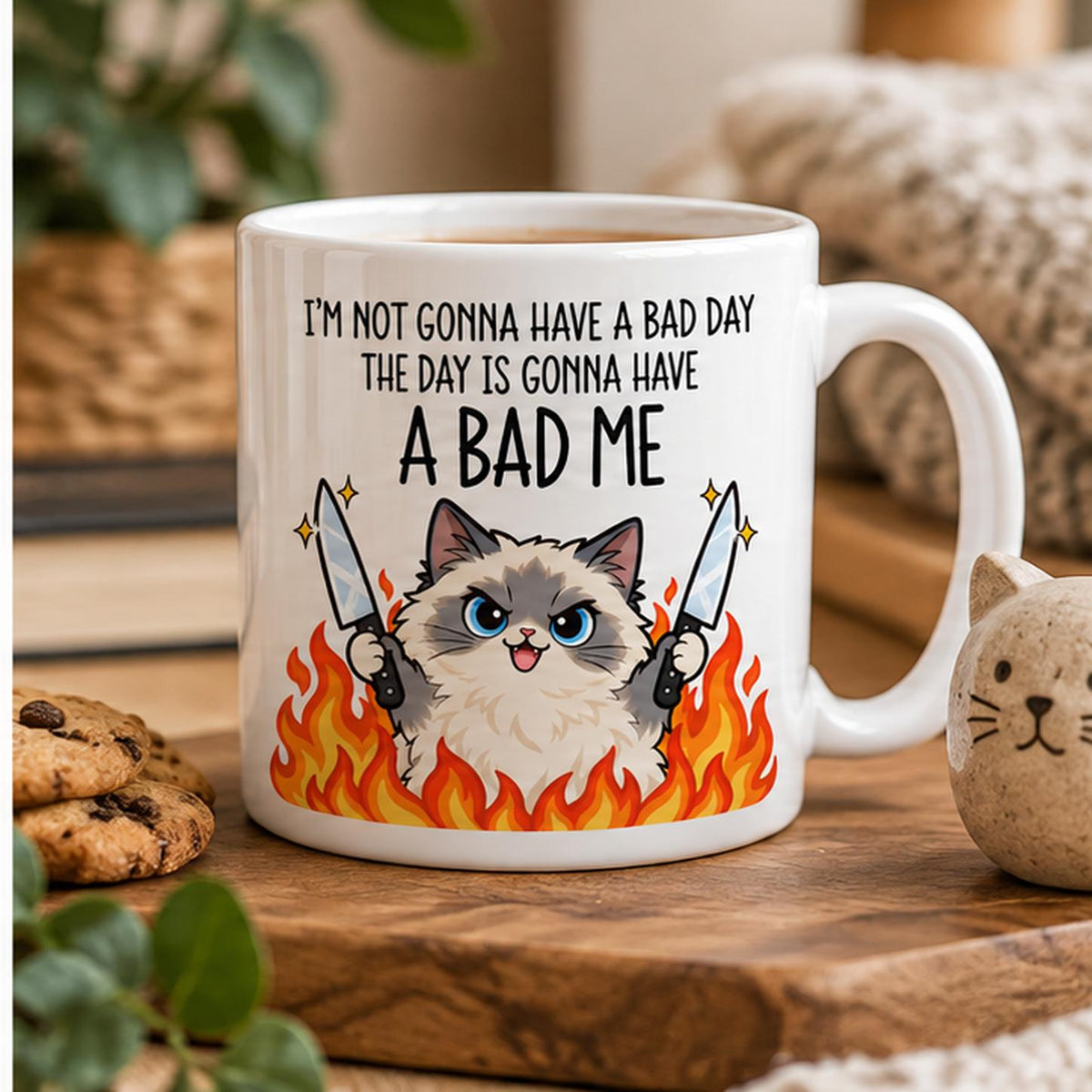Rendering of white ceramic mug with cartoon pumped ragdoll cat saying "I'm not gonna have a bad day" on wooden table. 