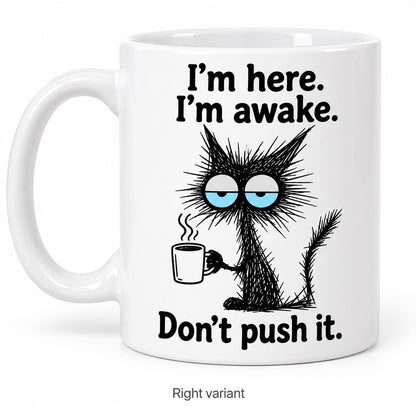 Rendering of white ceramic mug with cartoon tired black cat saying "I'm here. I'm awake. Don't push it." on white background. Print on right side view.