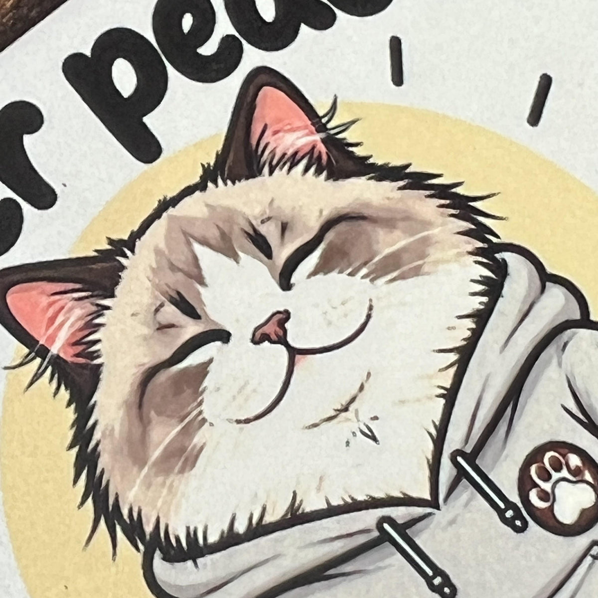 Detail tisku na korkový podtácek s kreslenou meditující ragdoll kočkou říkající "Inner peace starts with four words ...".